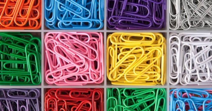 Paperclips in a plastic tray, each color sorted into a specific square within the tray.