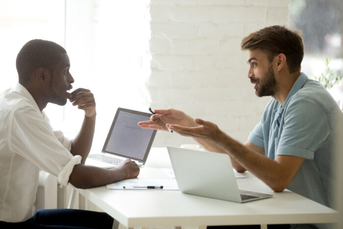 African-American and caucasian businessmen share interesting ideas project plans at workplace.