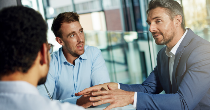 Group of men sitting at table talking