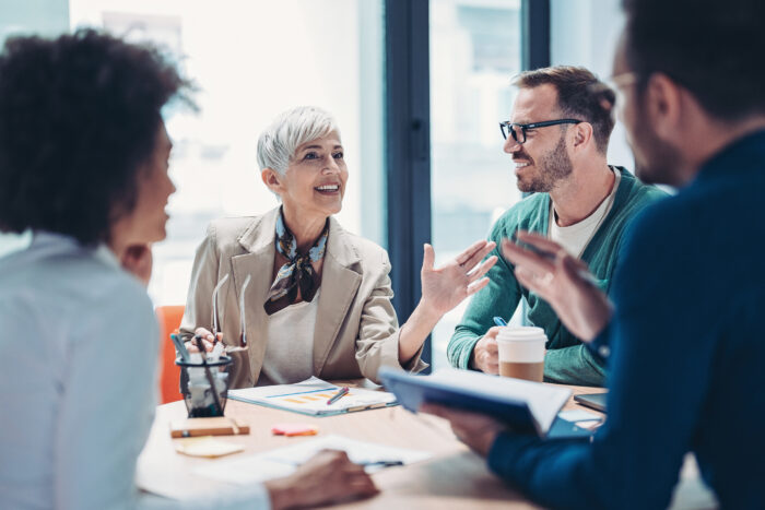 Mixed group of business people sitting around a table and talking