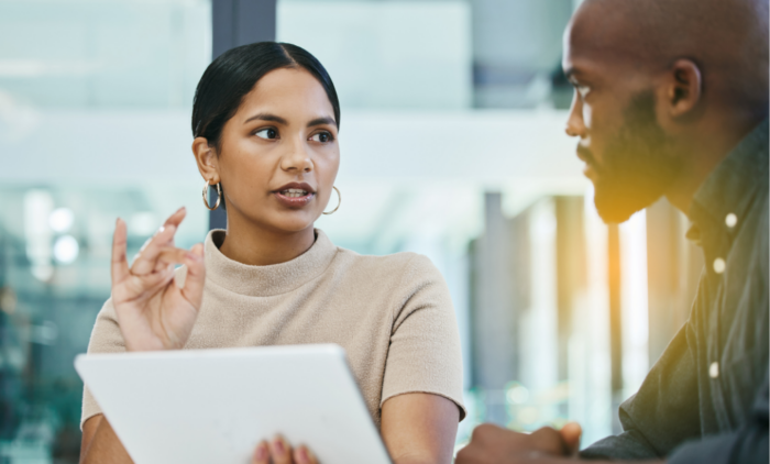 woman showing a man a tablet and explaining