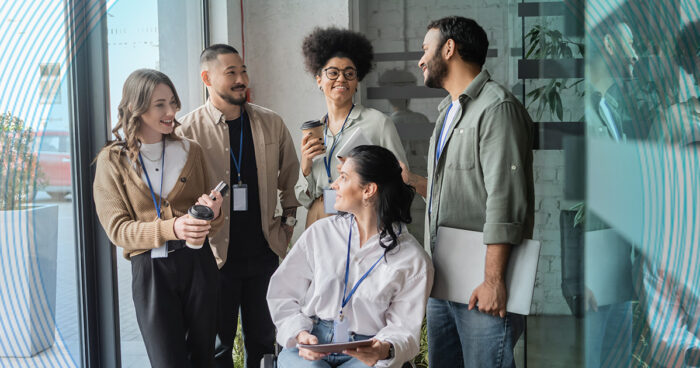 Decorative photo of five coworkers engaged in cordial conversation.