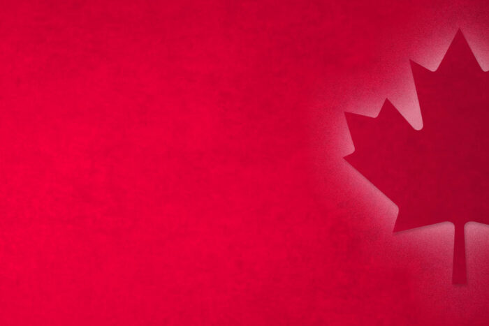 red hero image with Canadian maple leaf illuminated